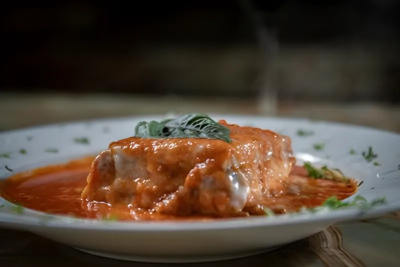 A baked dish in tomato cream sauce topped with basil