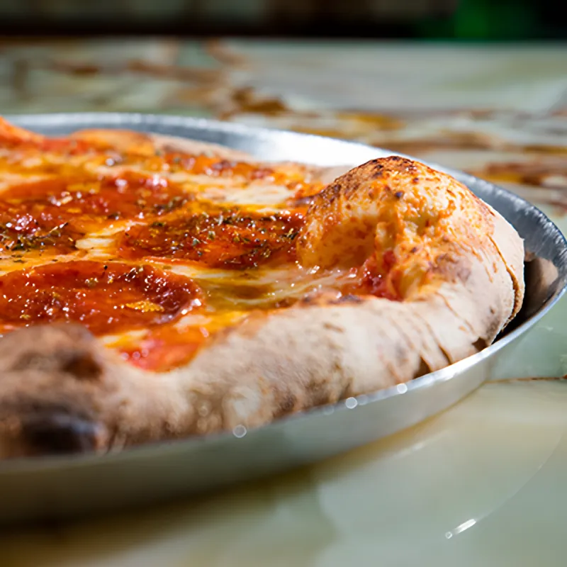 Close view of a pepperoni Diavola pizza with a puffed, charred crust
