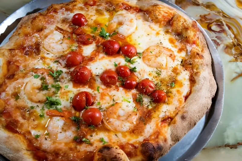 Shrimp pizza with marinated cherry tomatoes and herbs